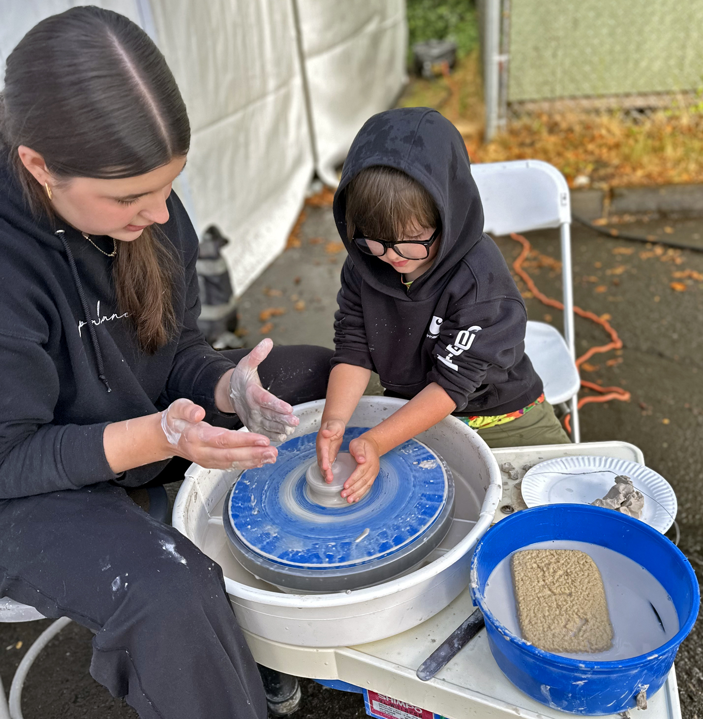 Children shaping clay at the Kids with Clay tent